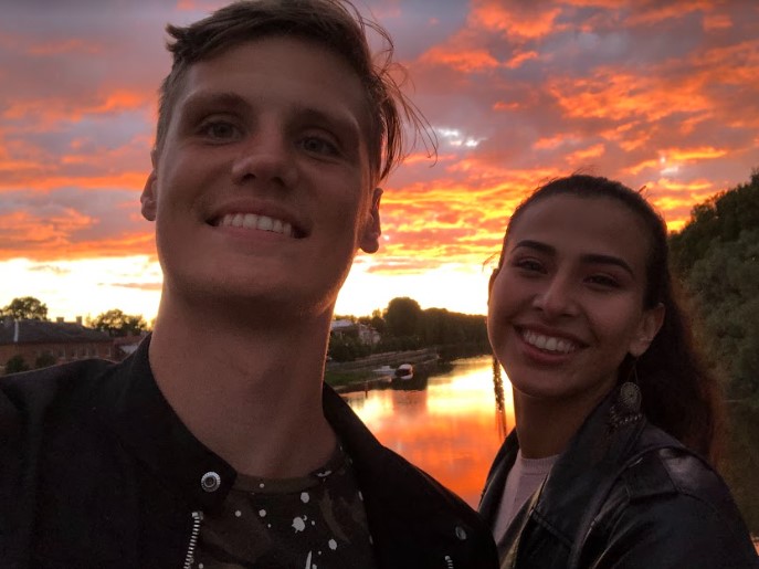 couple smiling with a sunset behind