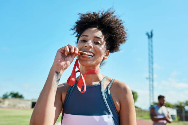 Woman biting marathon finisher medal