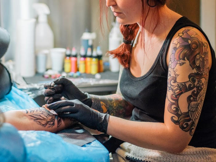 woman tattooing