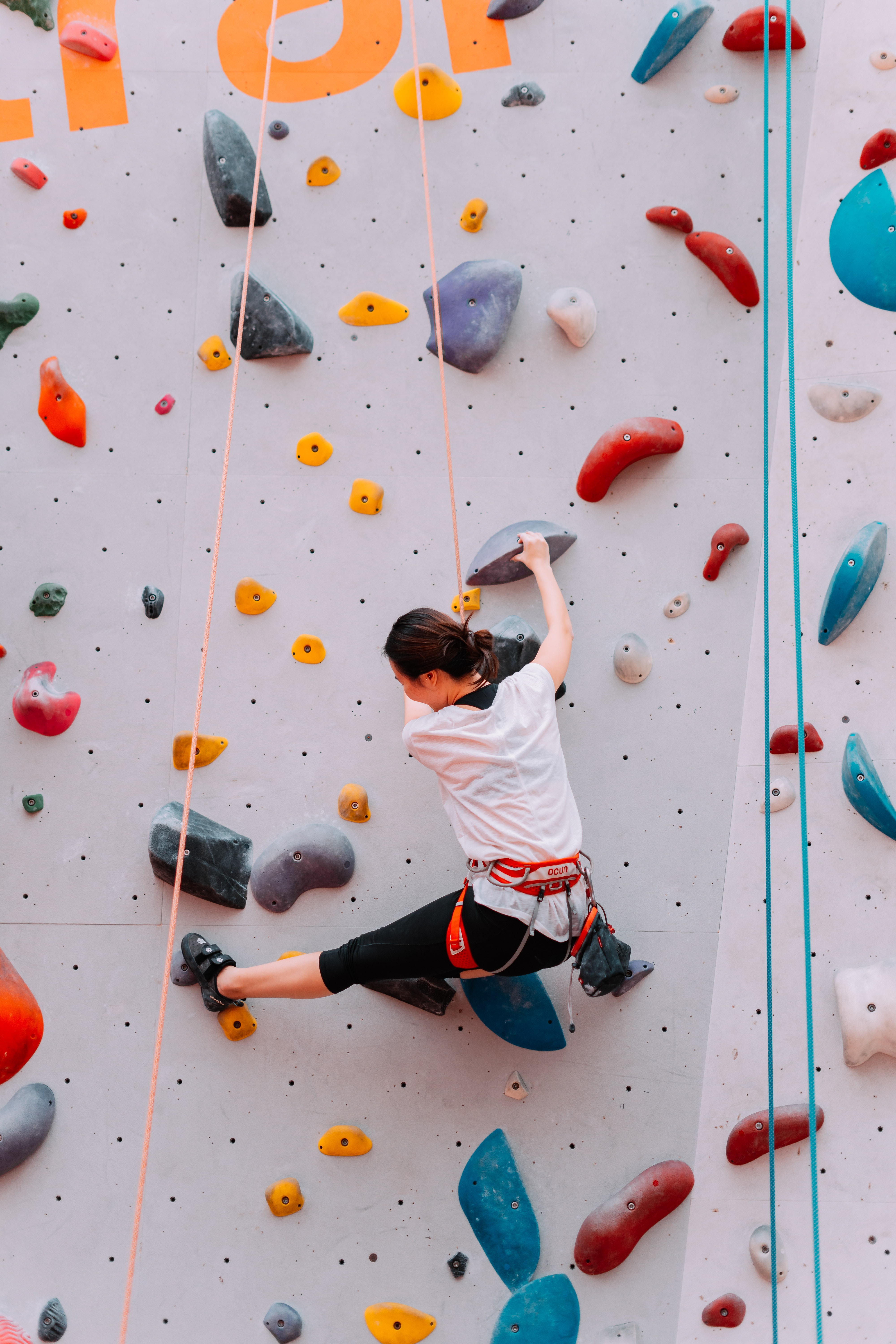Woman climbing an indoor rock wall
