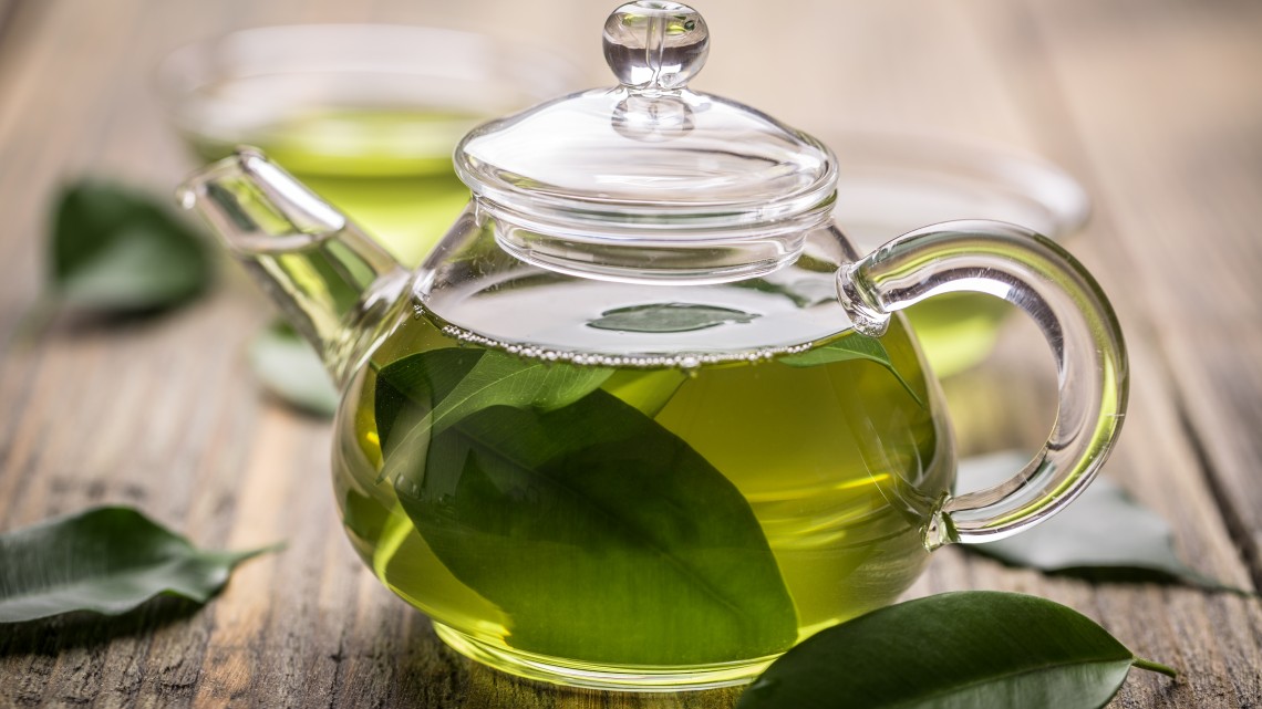 Green tea in a glass teapot