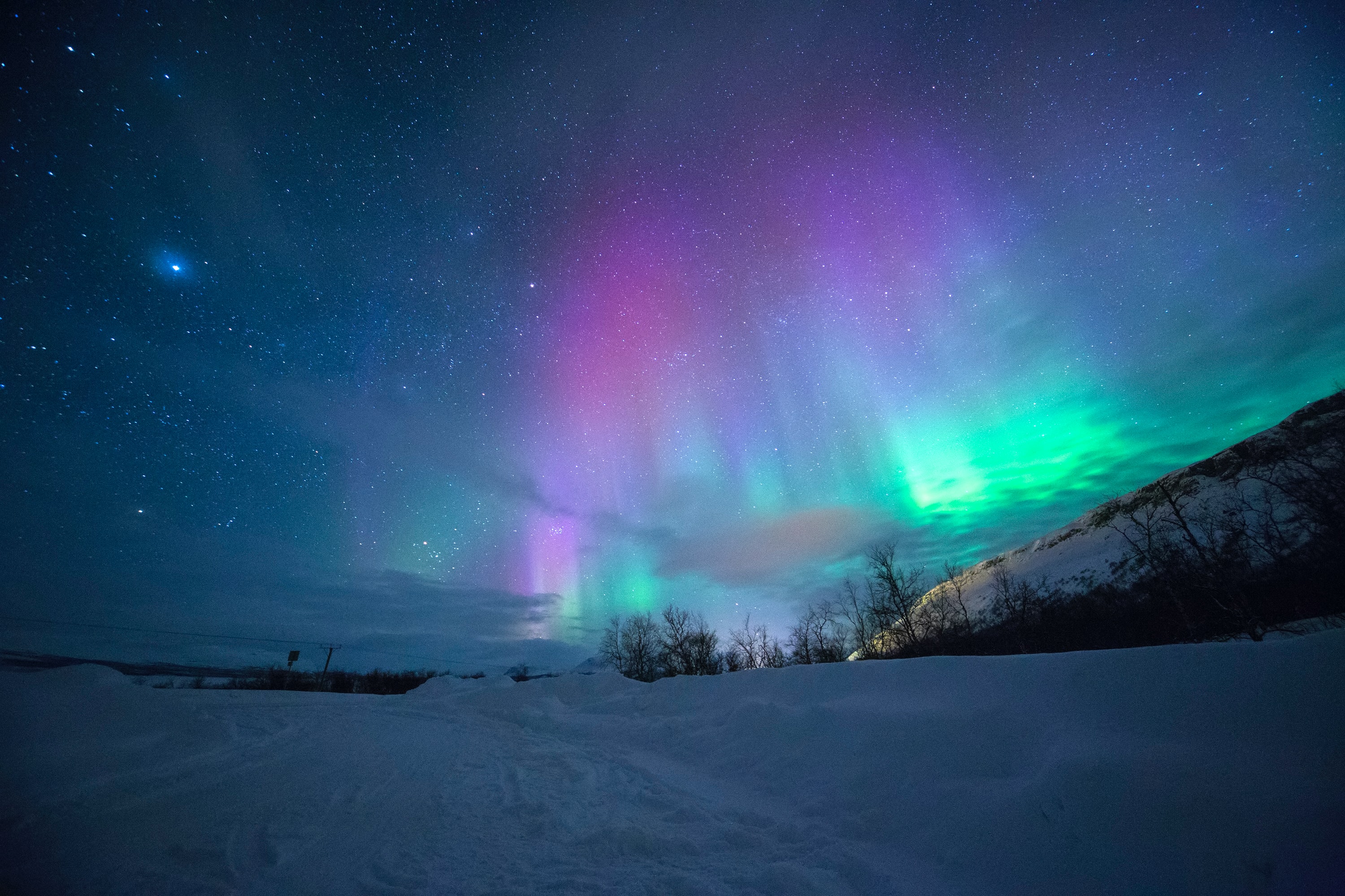 Northern lights in the sky with a mountain at the center