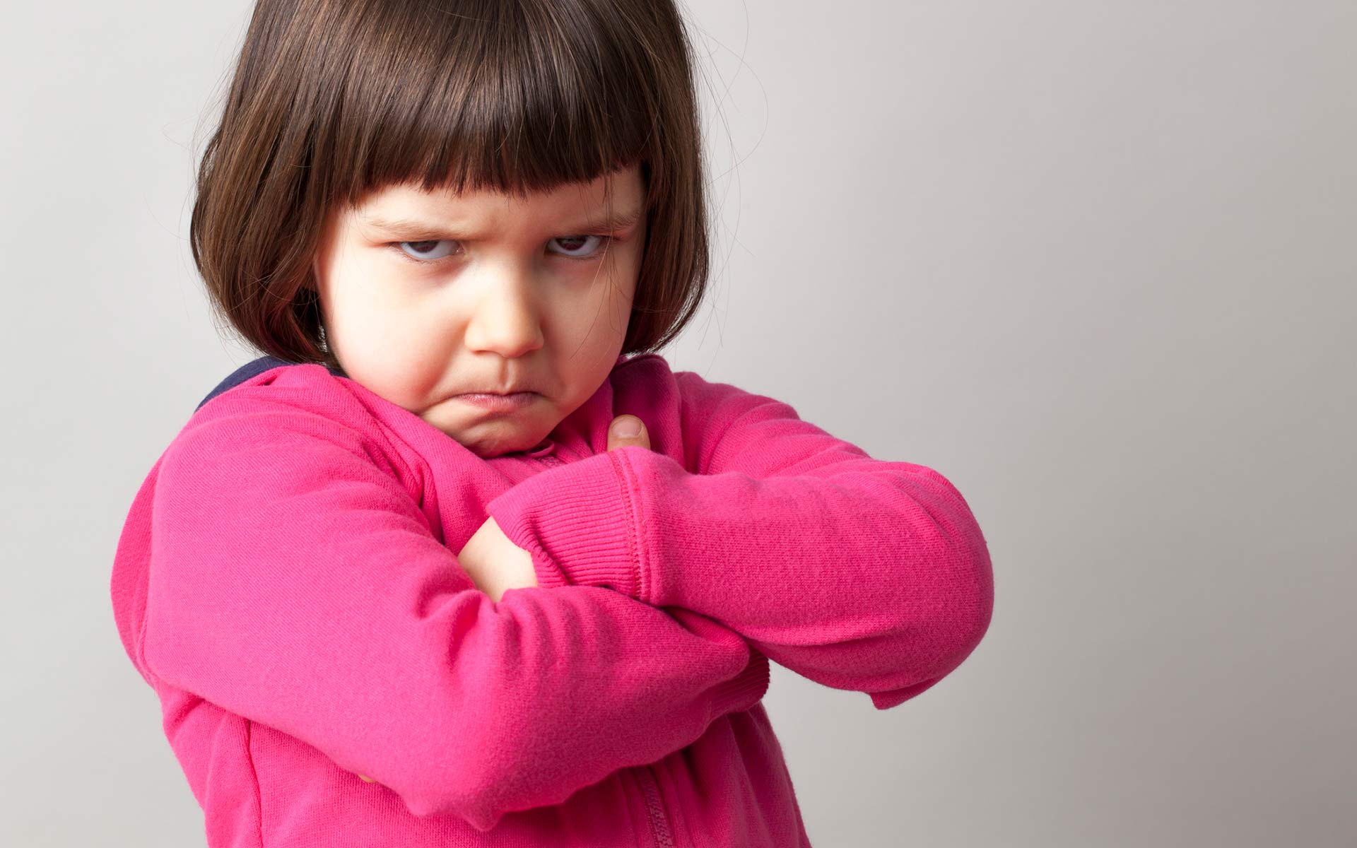 Kid with it's arms folded, showing a displeased face