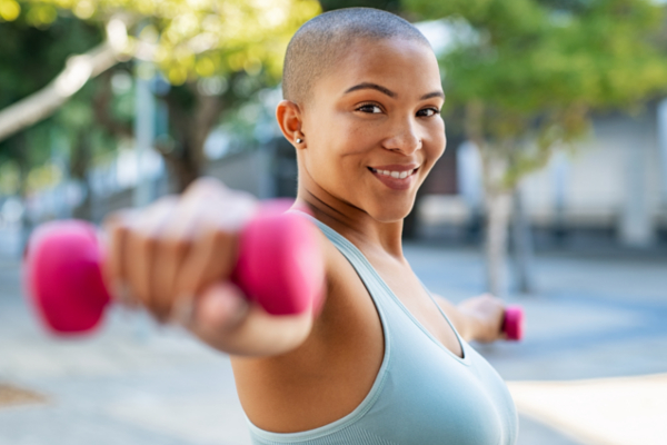 Woman smiling with weights in hand
