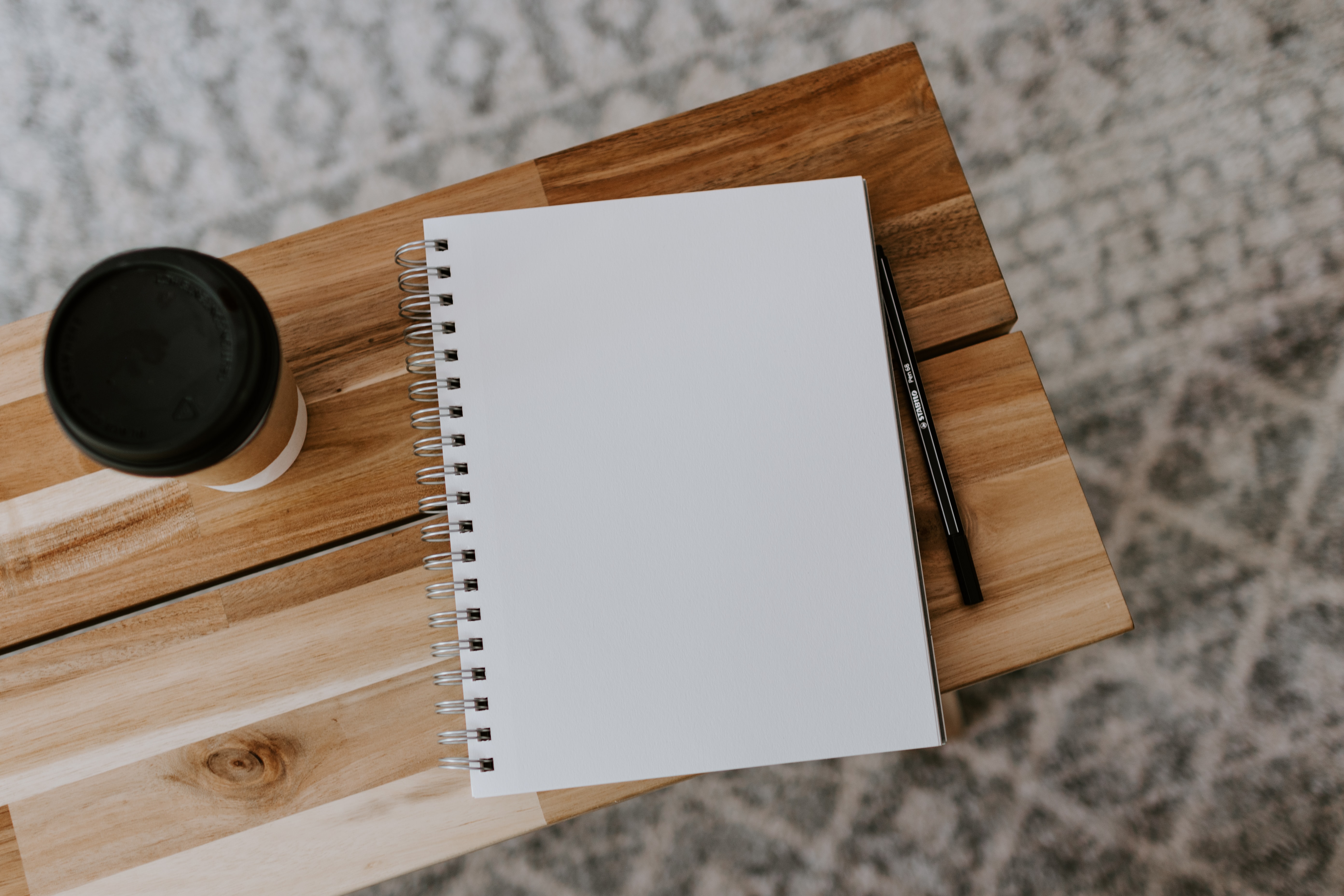Notebook and coffee on a wooden table