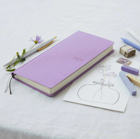A lavender coloured 2023 planner on a desktop