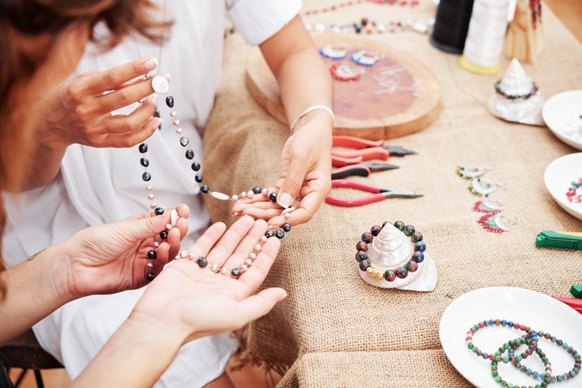 Woman making beaded jewelry