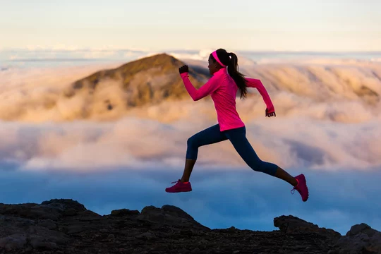 girl running at sunset on mountain trail