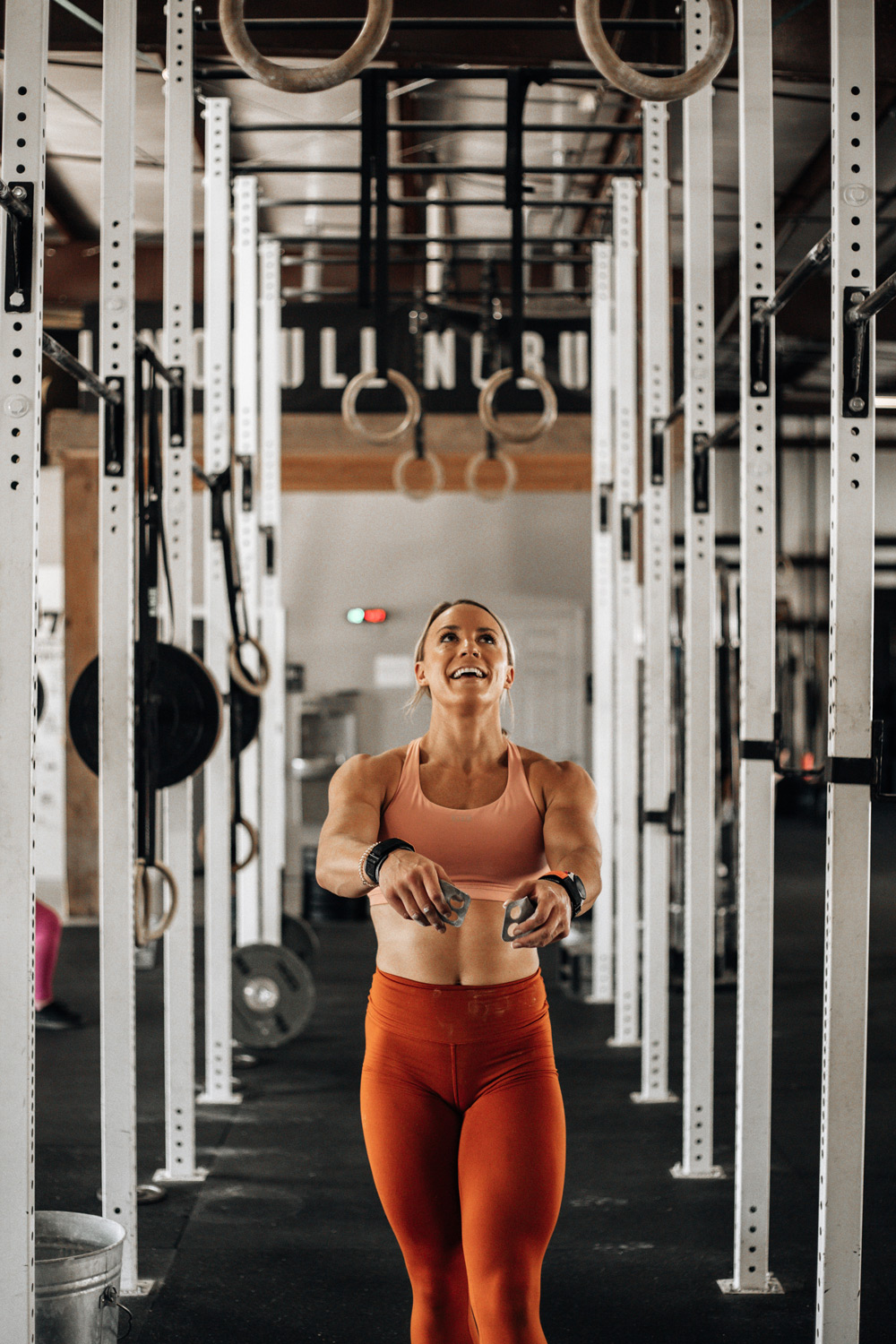 Woman looking at hanging rings comtemplating a ring muscle up