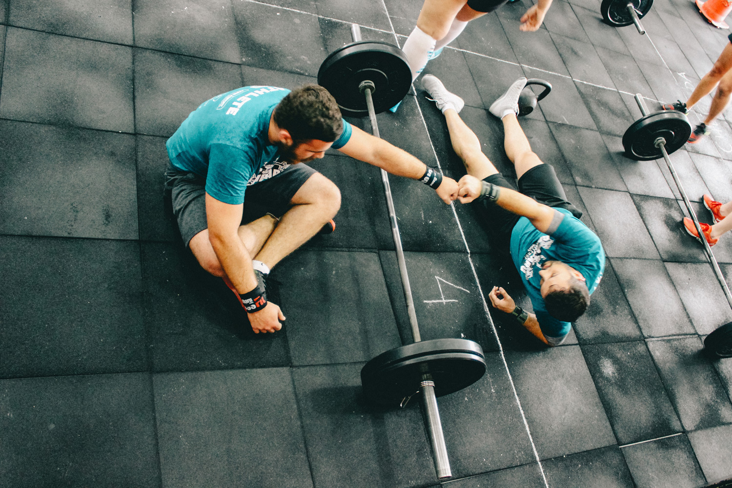 Men sitting and lying on floor after finishing exercise