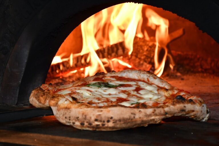 neapolitan pizza getting out of the wood fire oven 