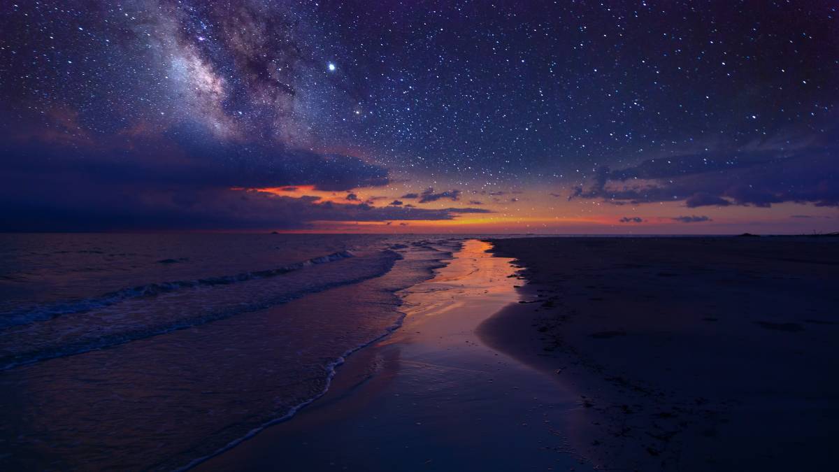 Image of milky way and a beach at sunset.