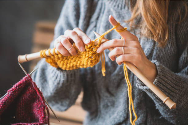 Woman knitting with yellow wool