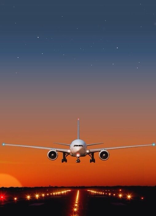 a plane landing on the runway during sunset