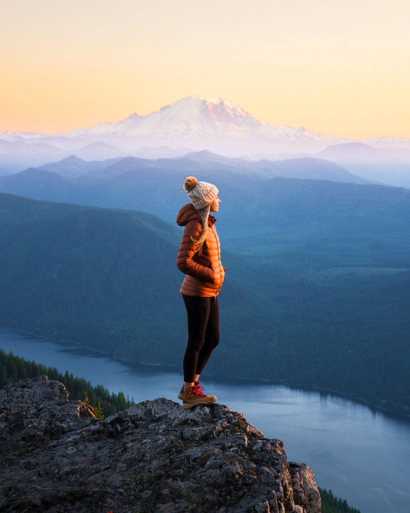 Woman standing at cliff on mountain
