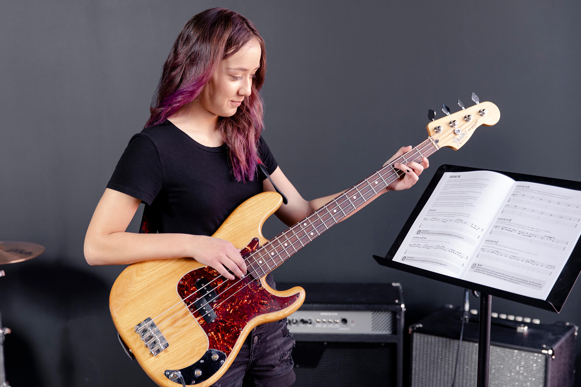 Girl with pink hair playing bass