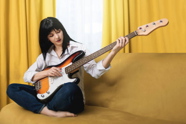 Woman playing bass on the sofa