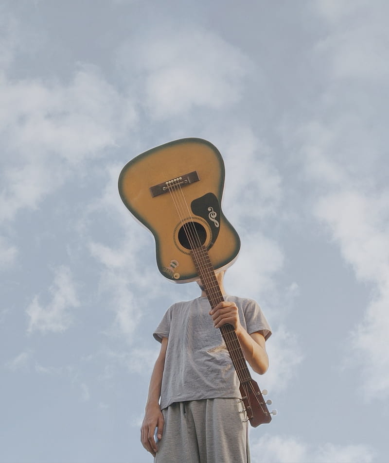 man holding guitar outside