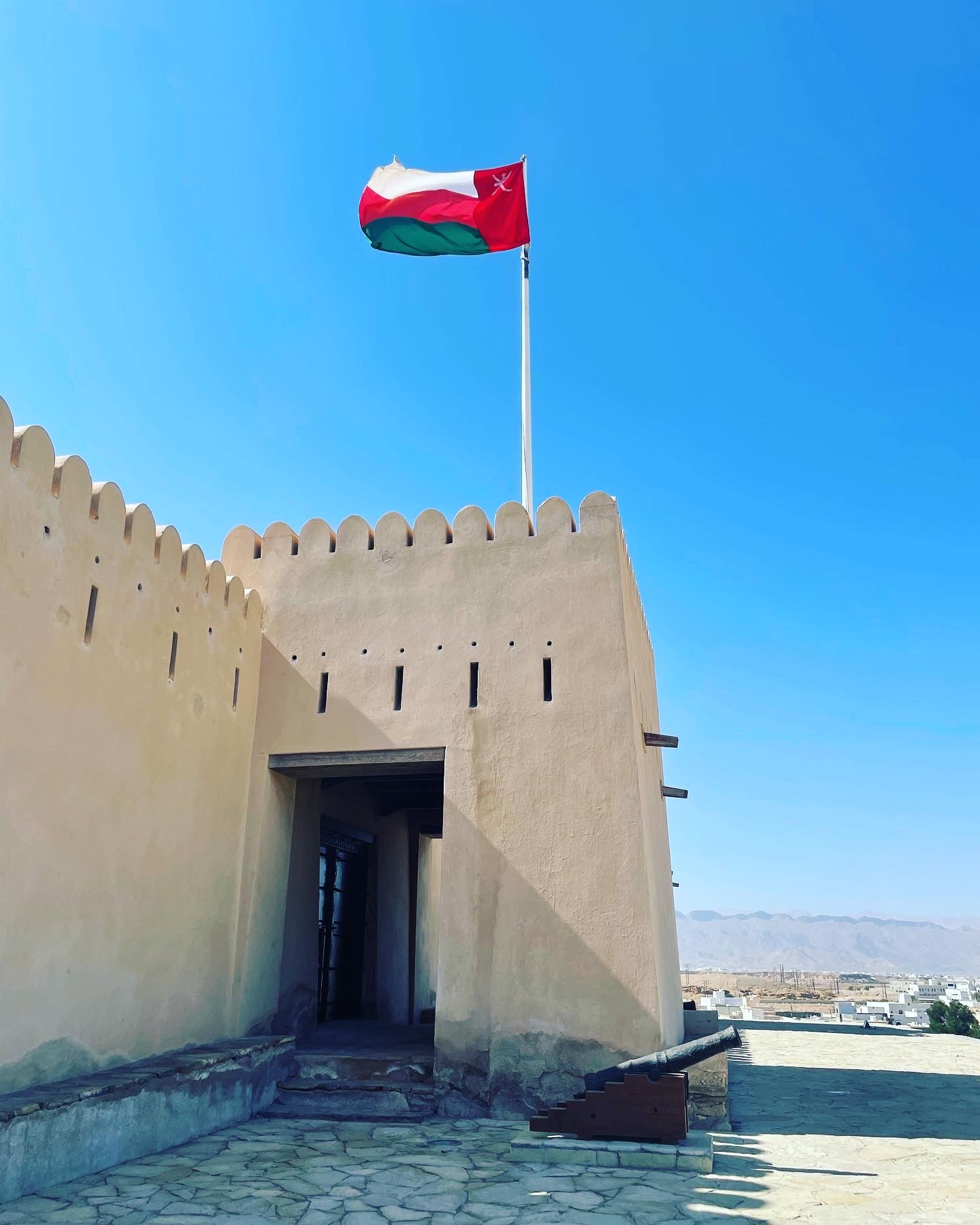 Image of Sur Castle with flag in Oman