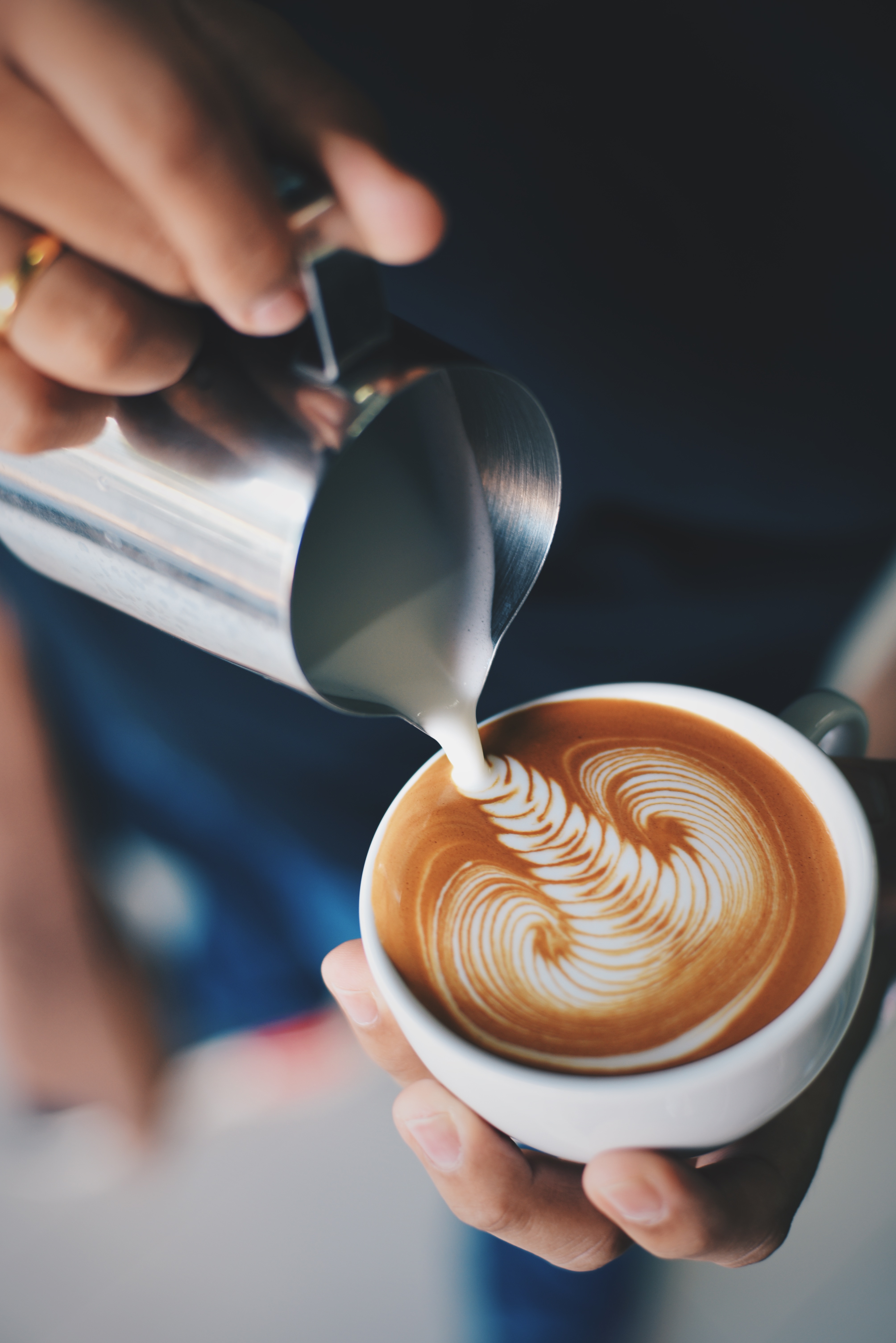 person serving latte with foam art