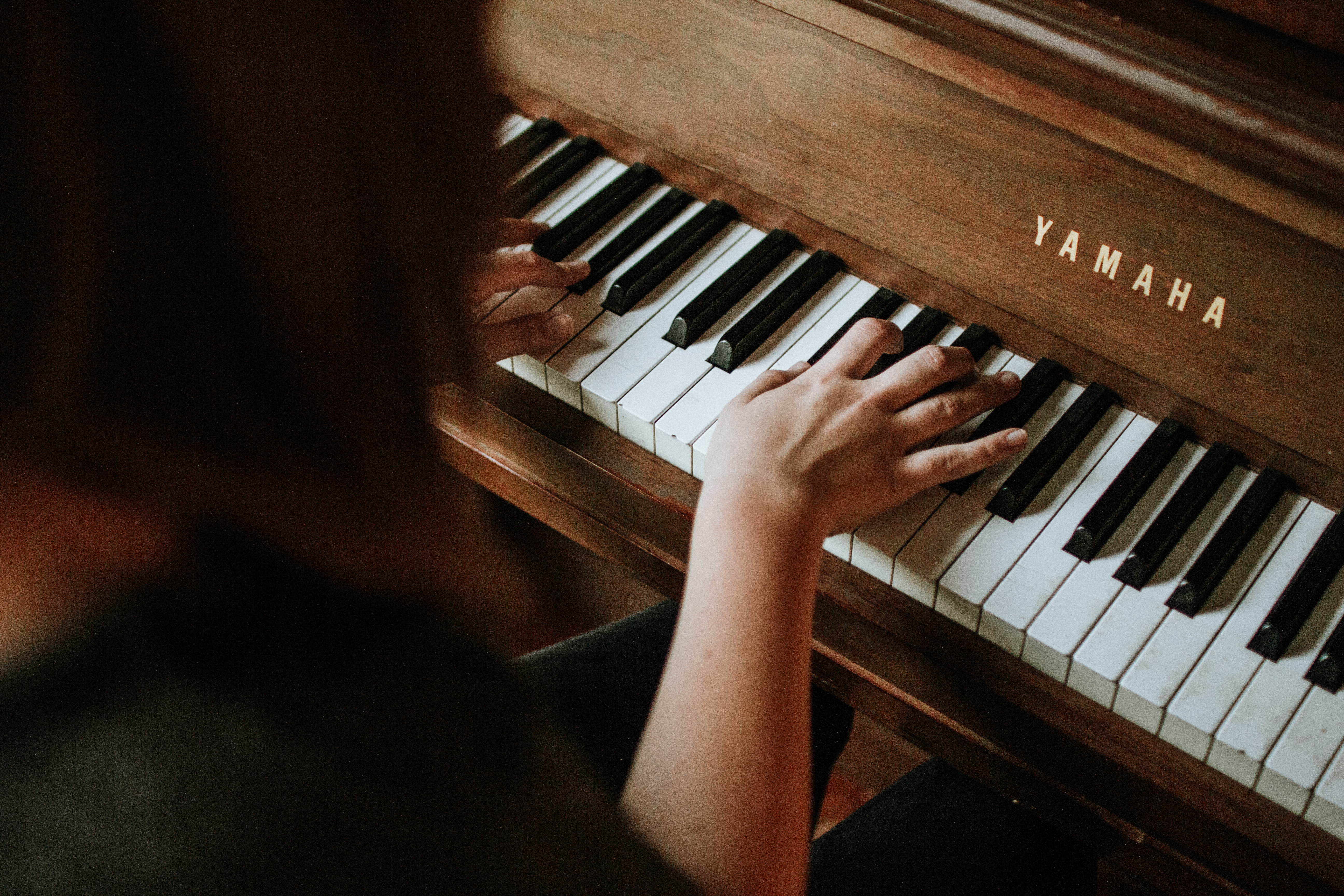 Woman playing Wooden Yamaha Piano