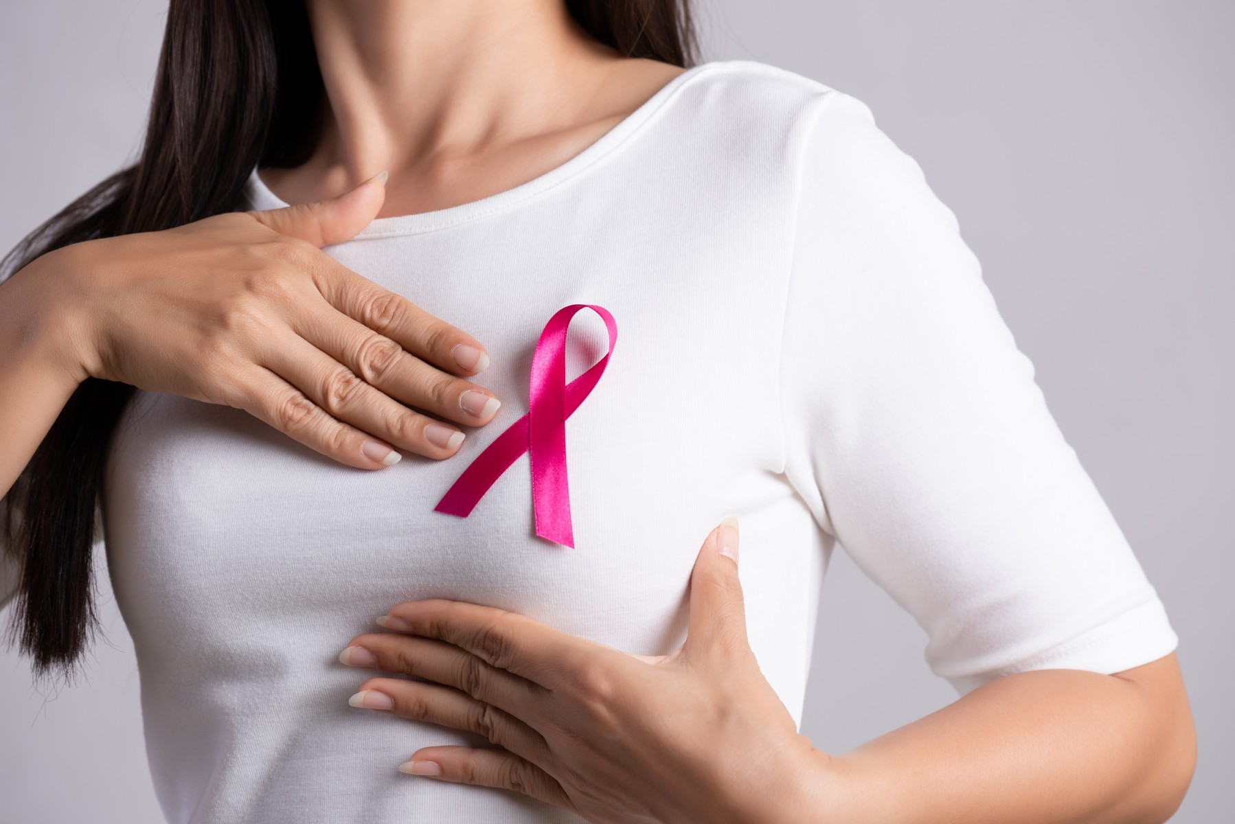 Woman with pink cancer ribbon on chest