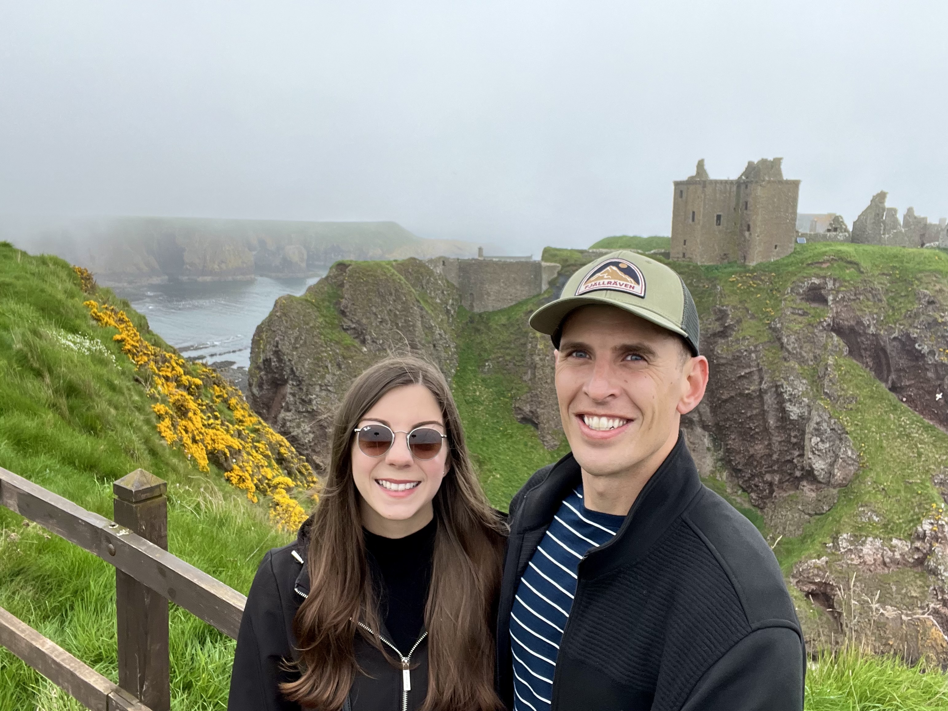 man and woman standing infront of a castle in Scotland