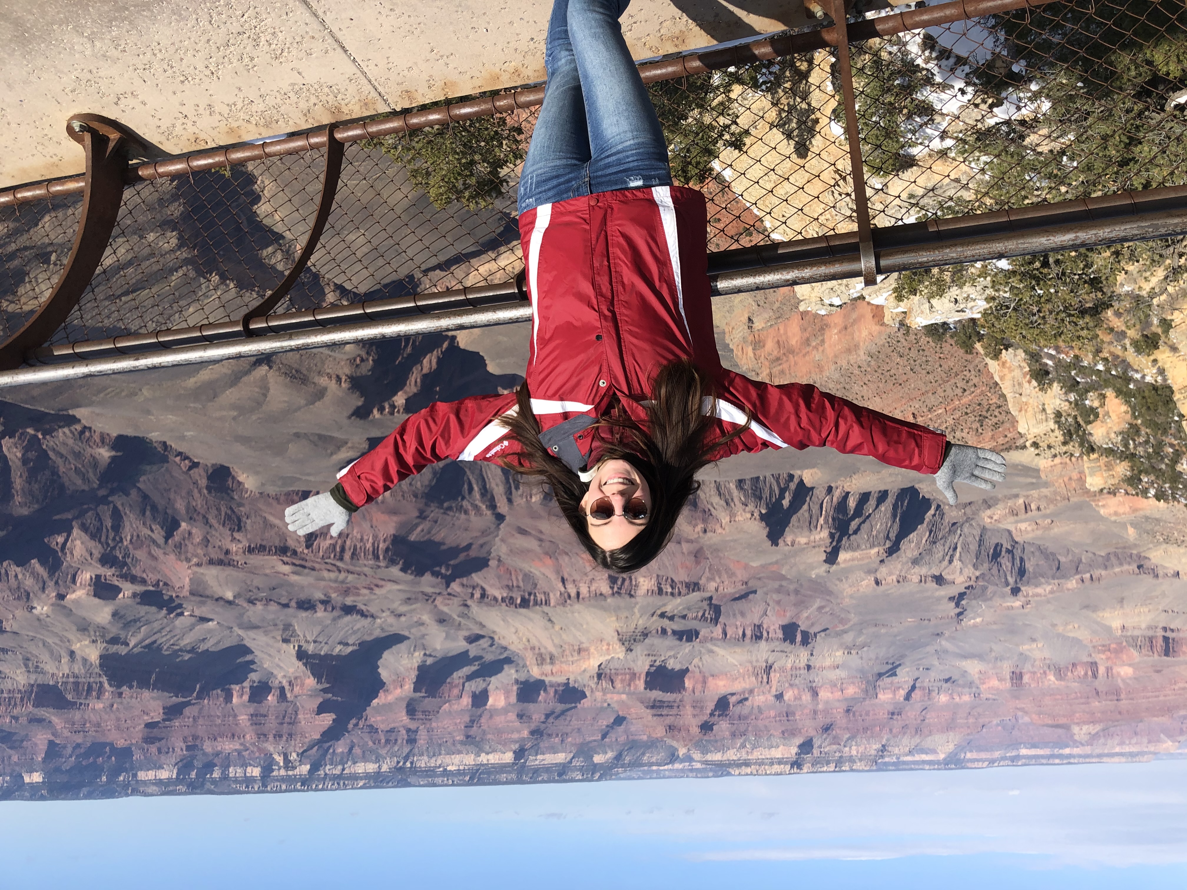 girl standing with arms spread open infront of Grand Canyon