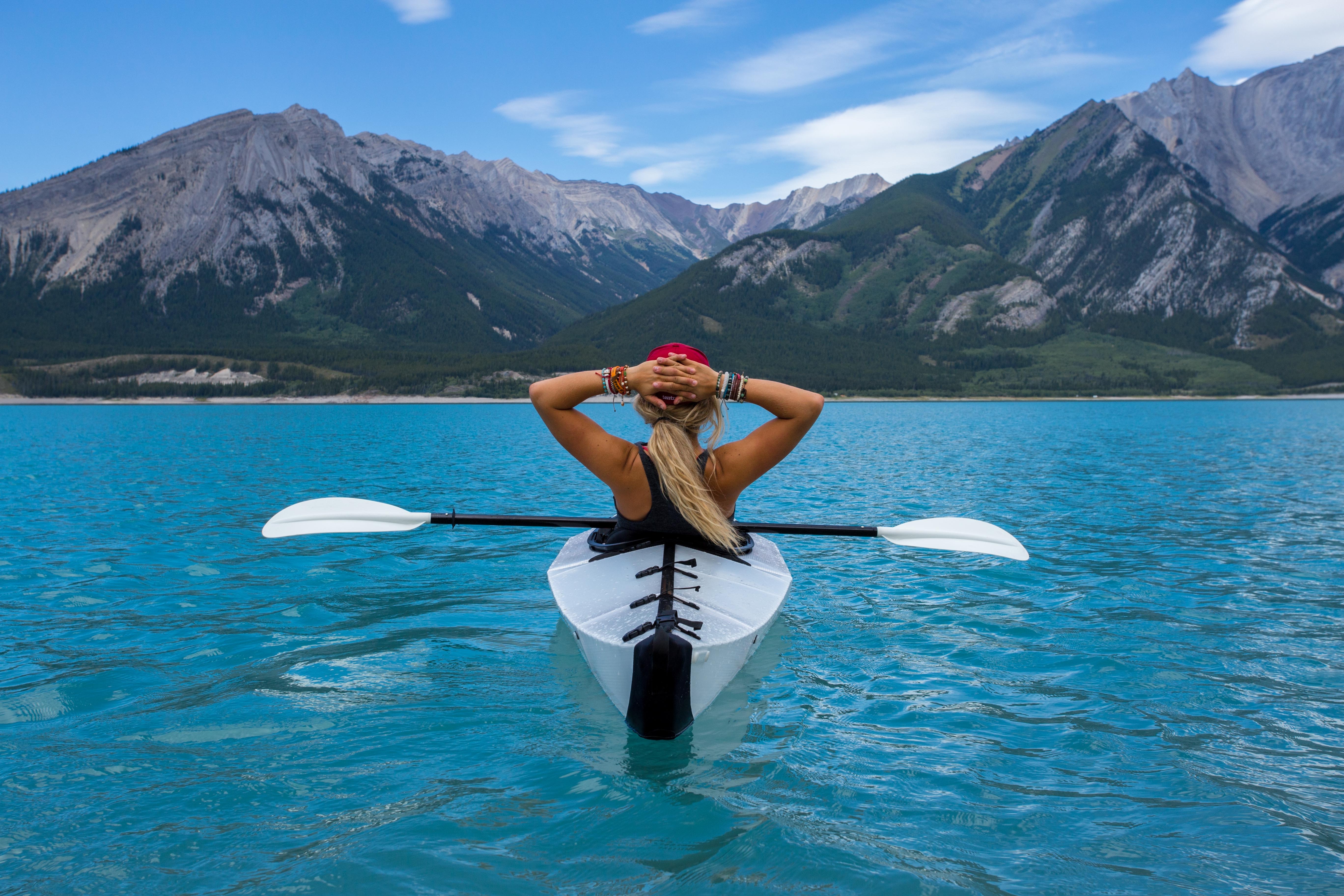 woman sitting in a kayak looking at the mountains