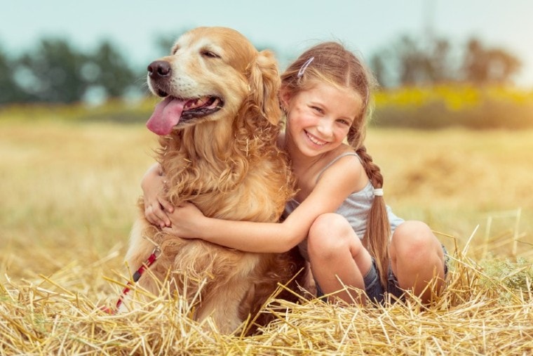 little girl hugging dog