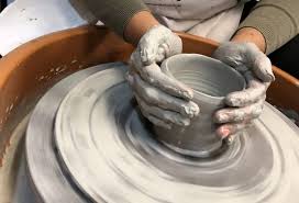 An image of a person making pottery on a+ wheel