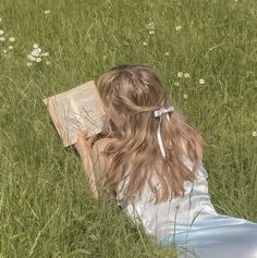 A photo of a woman reading in a field