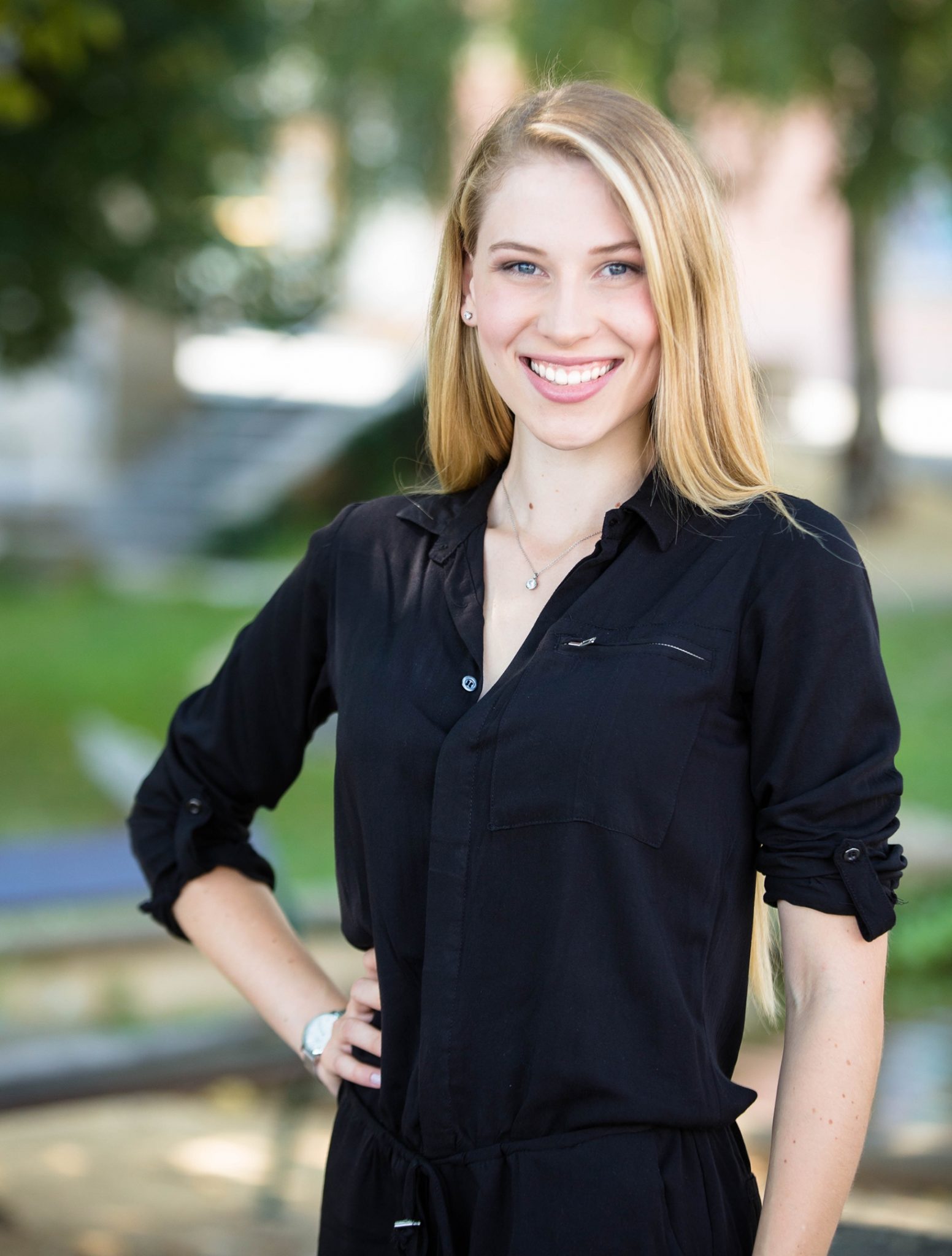 Stylish blonde woman in sleek black jumpsuit posing for a photo 