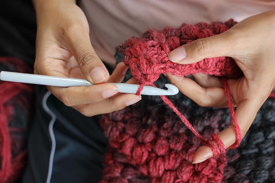A picture of a person crocheting