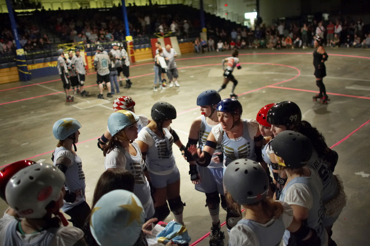 Roller derby players in a huddle