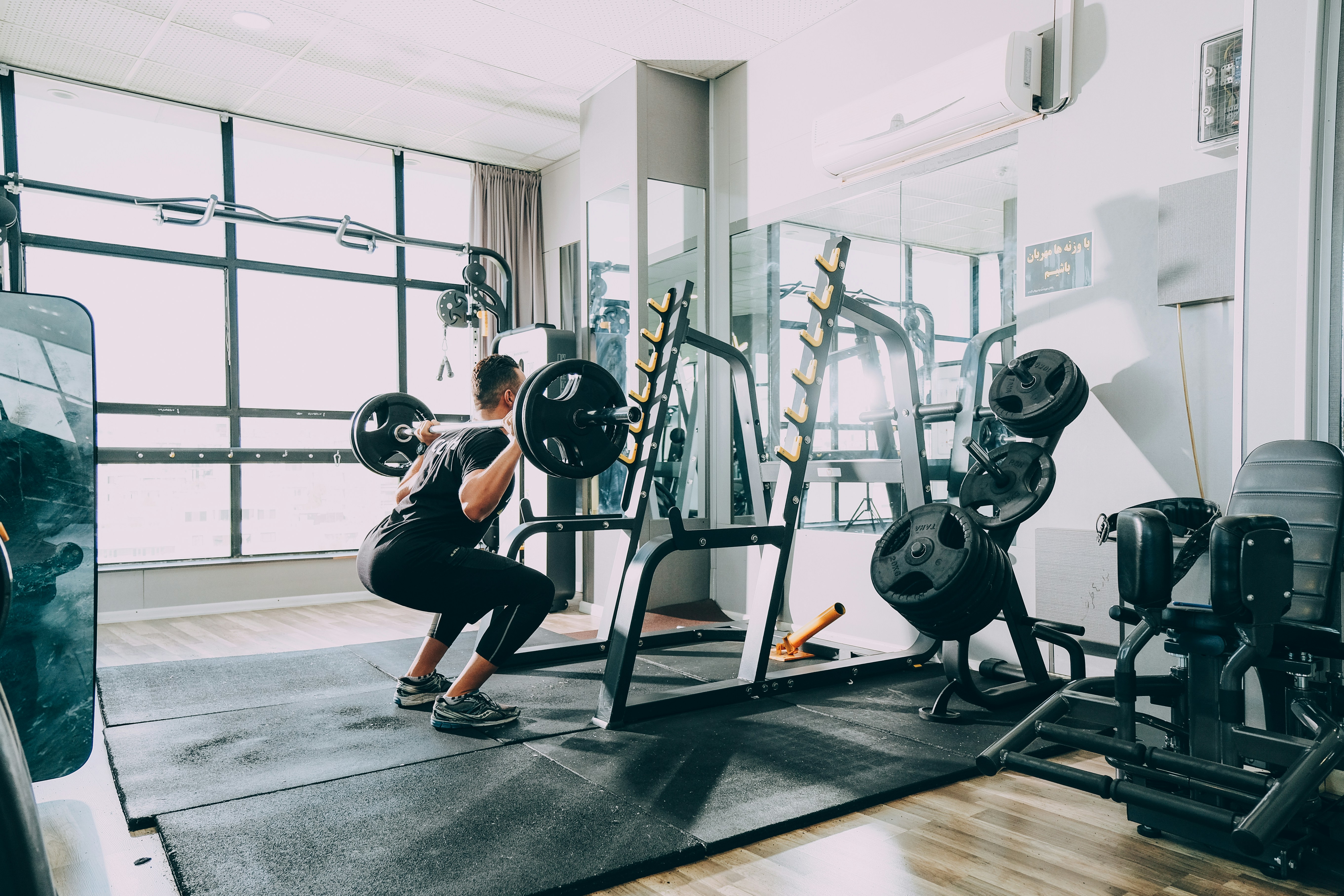 man performing a barbell squat