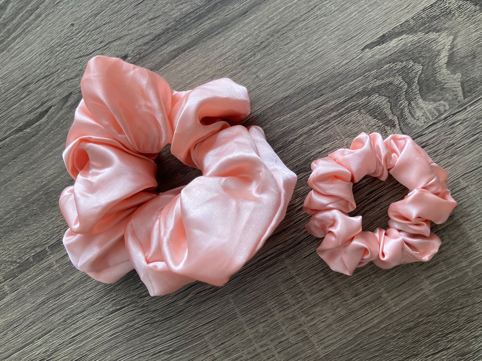 A handmade light pink scrunchie.