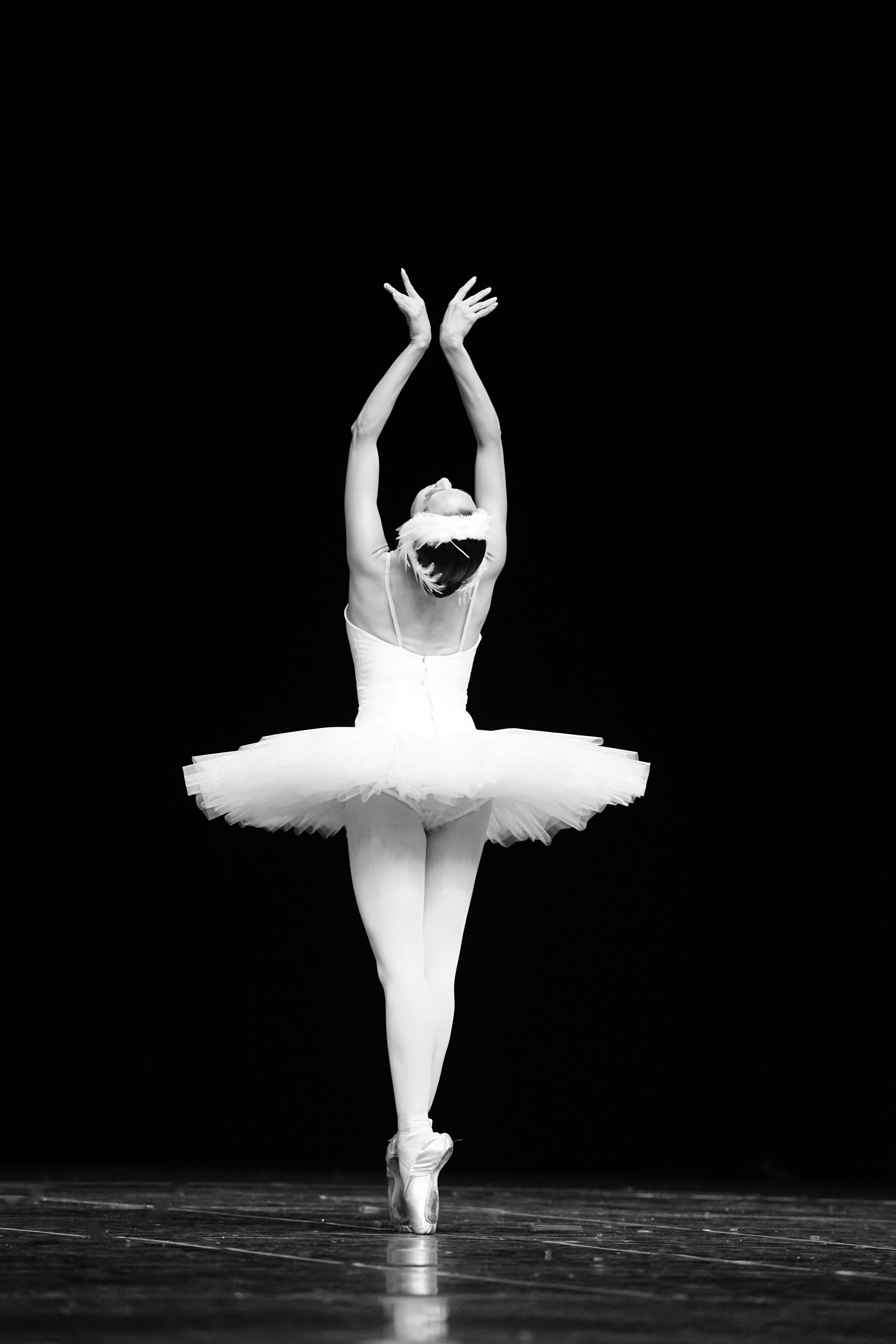 Black and white photo of a ballerina dacing with arms up