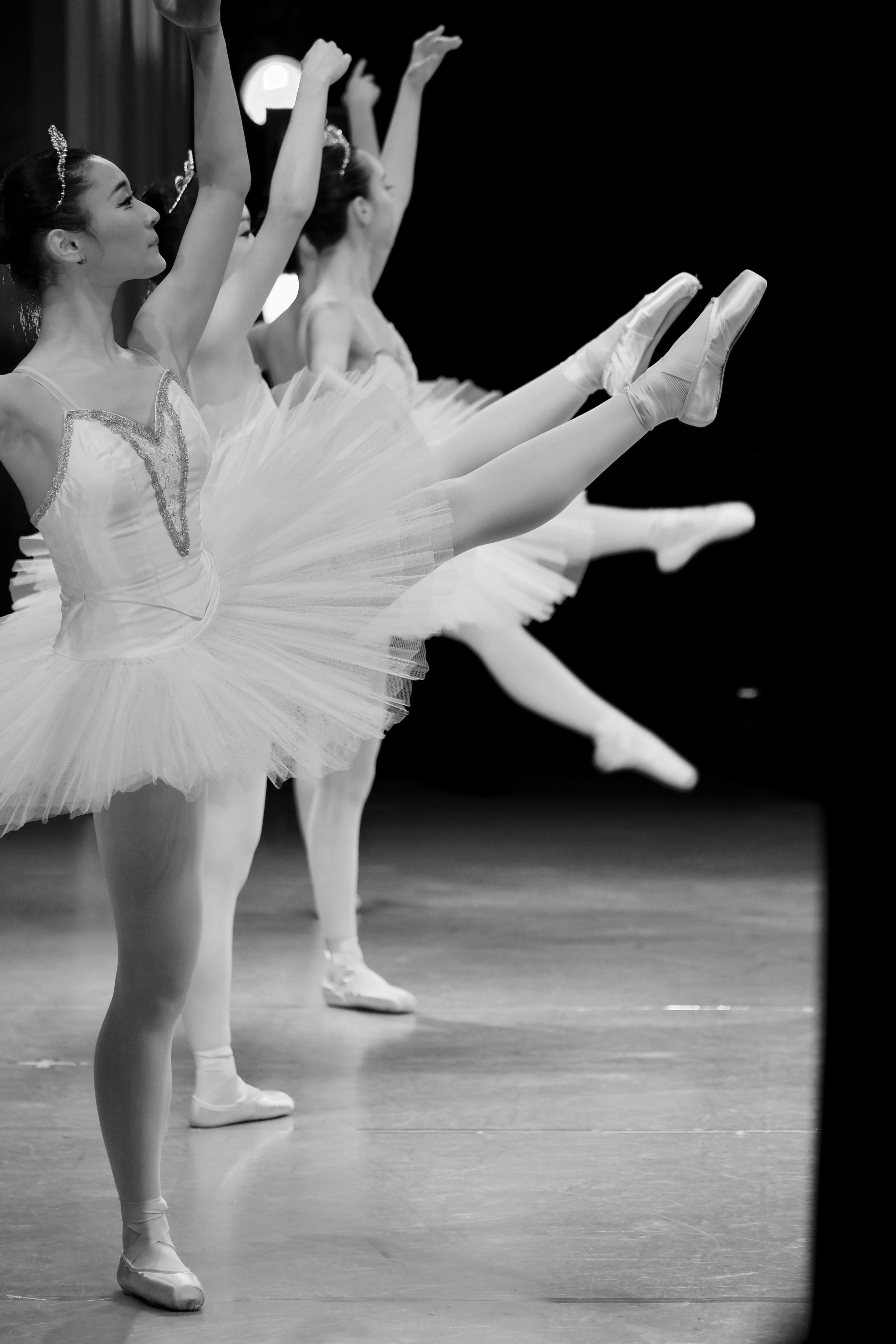 Black and white photo of a group of ballerinas dancing on stage
