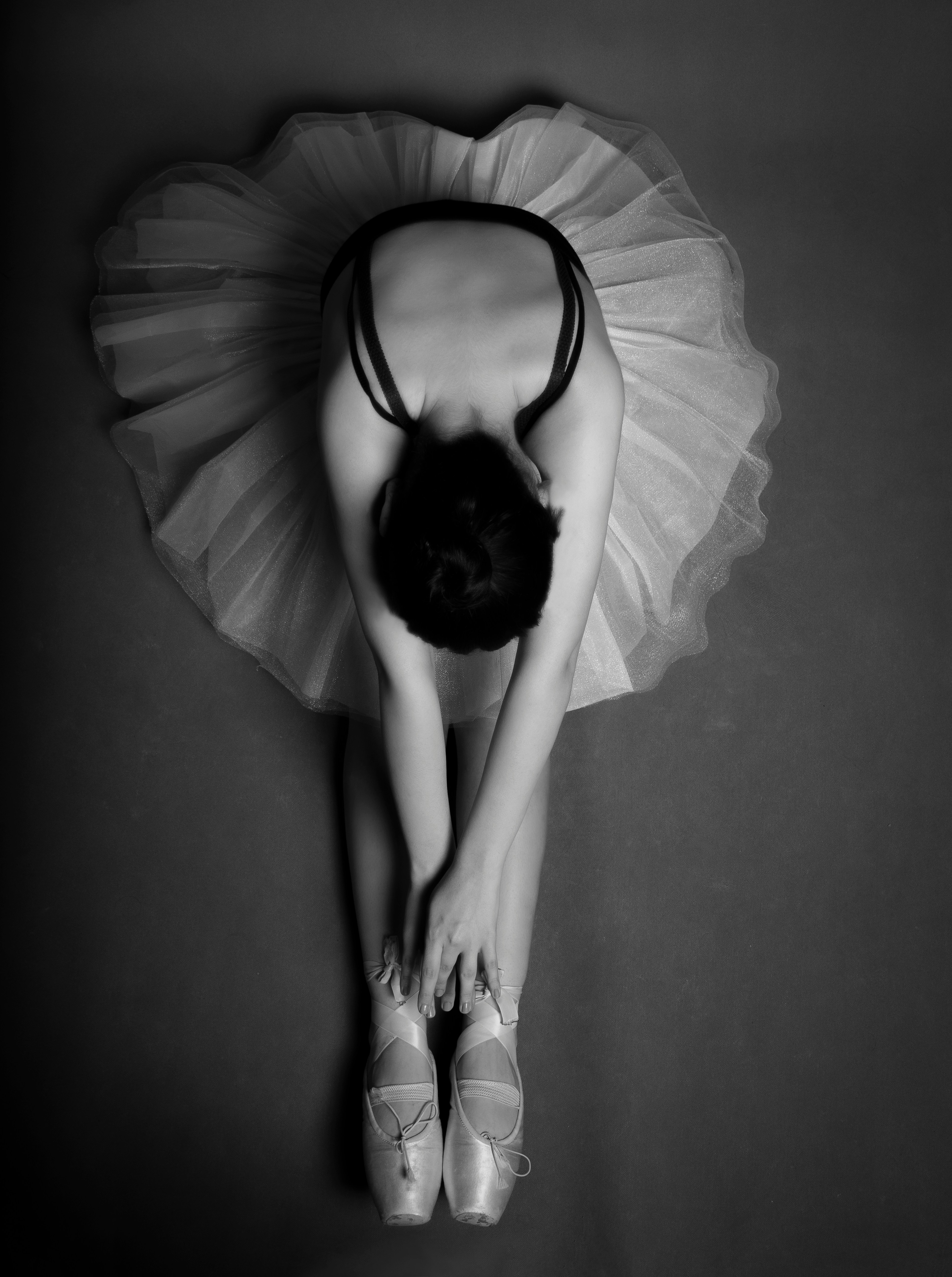 Black and white photo of a dancer streching on the floor