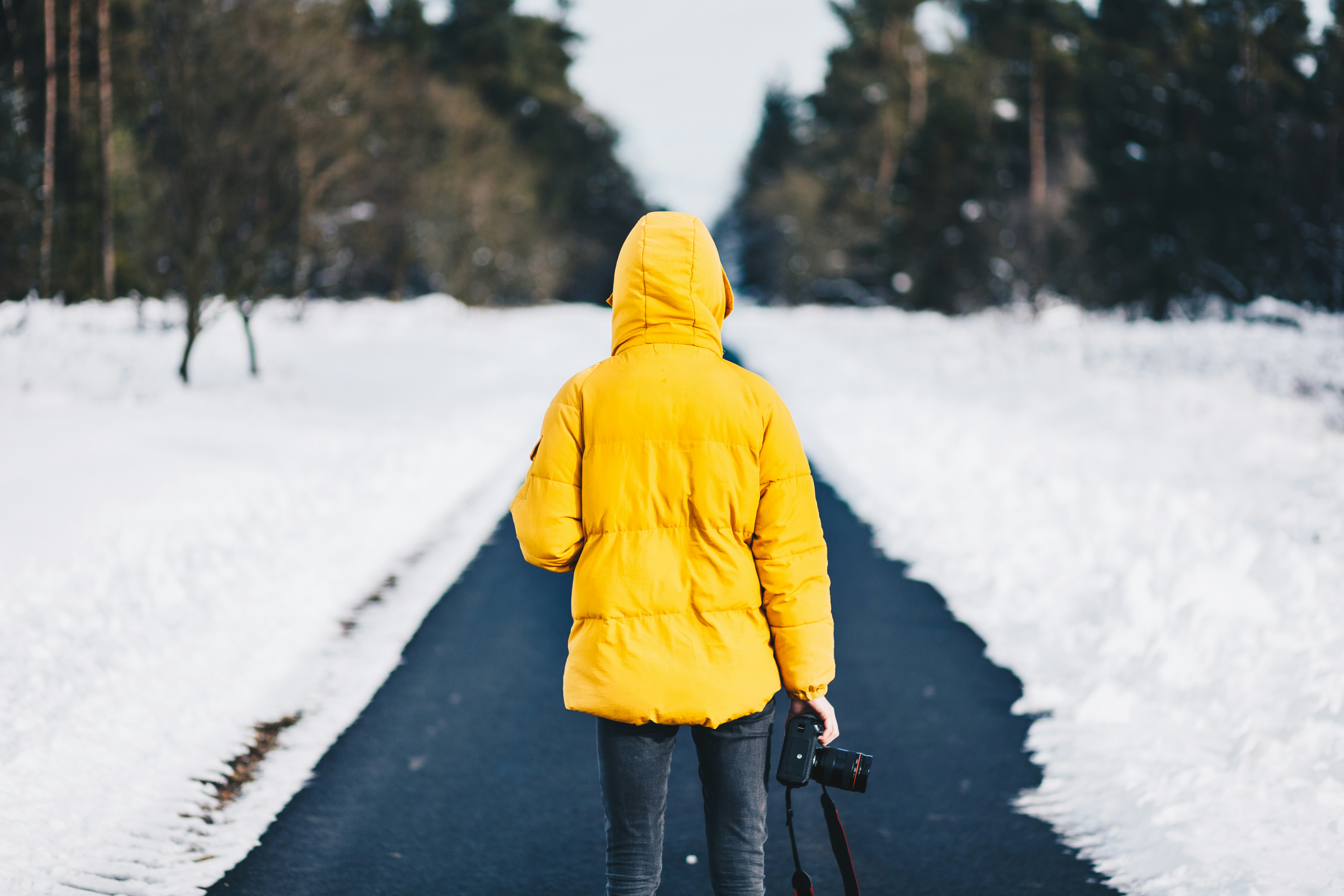 photograph of a woman holding a camera on a snowy street