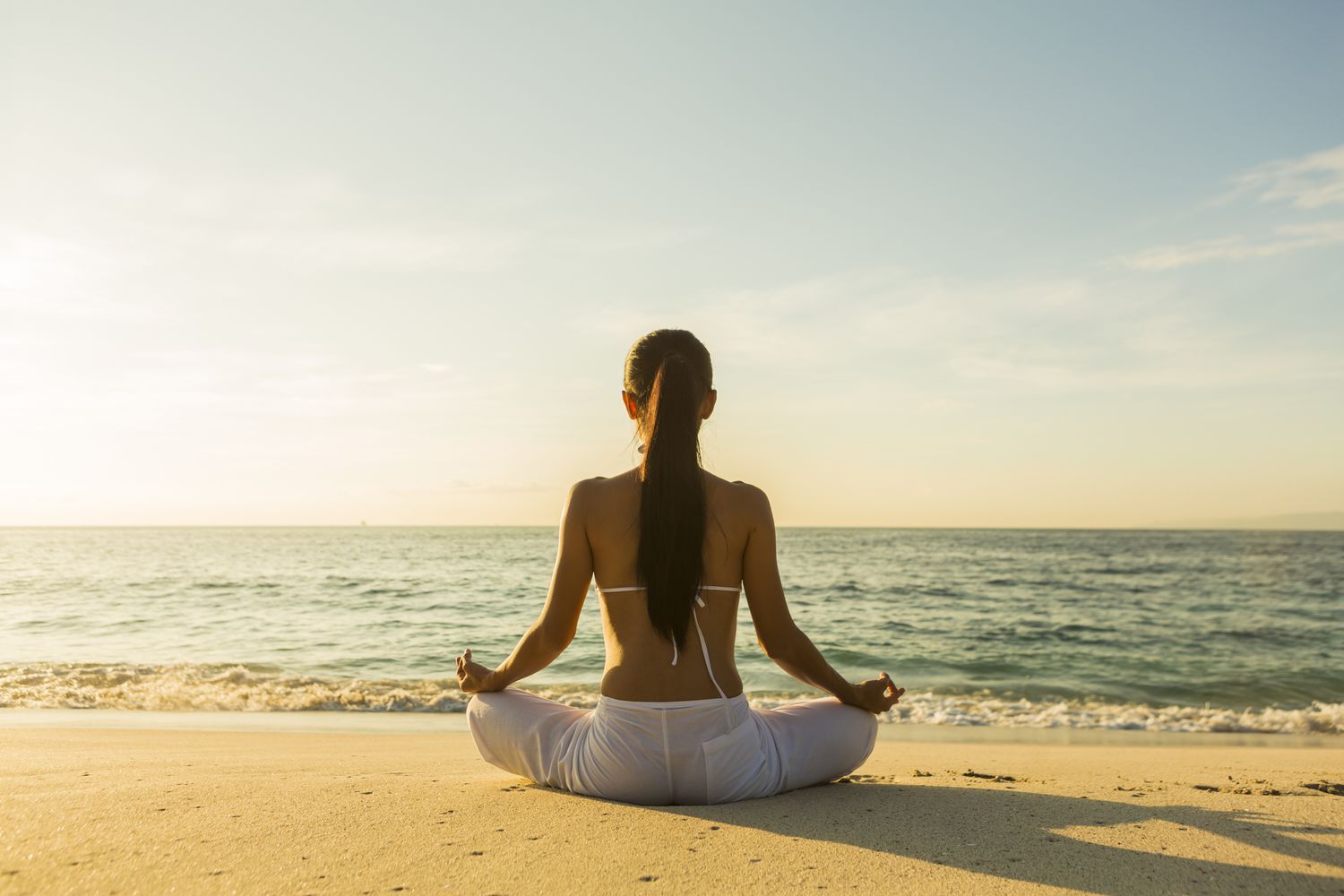 Woman meditating on the beach