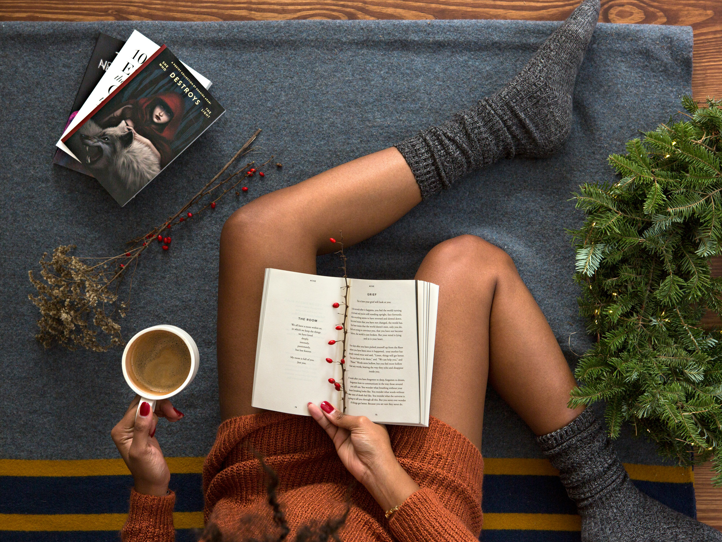 woman with a book on her legs and coffee