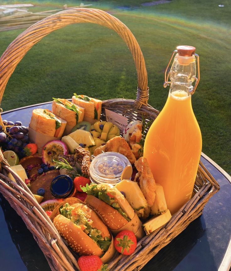 Full picnic basket with sandwiches, pastires and orange juice