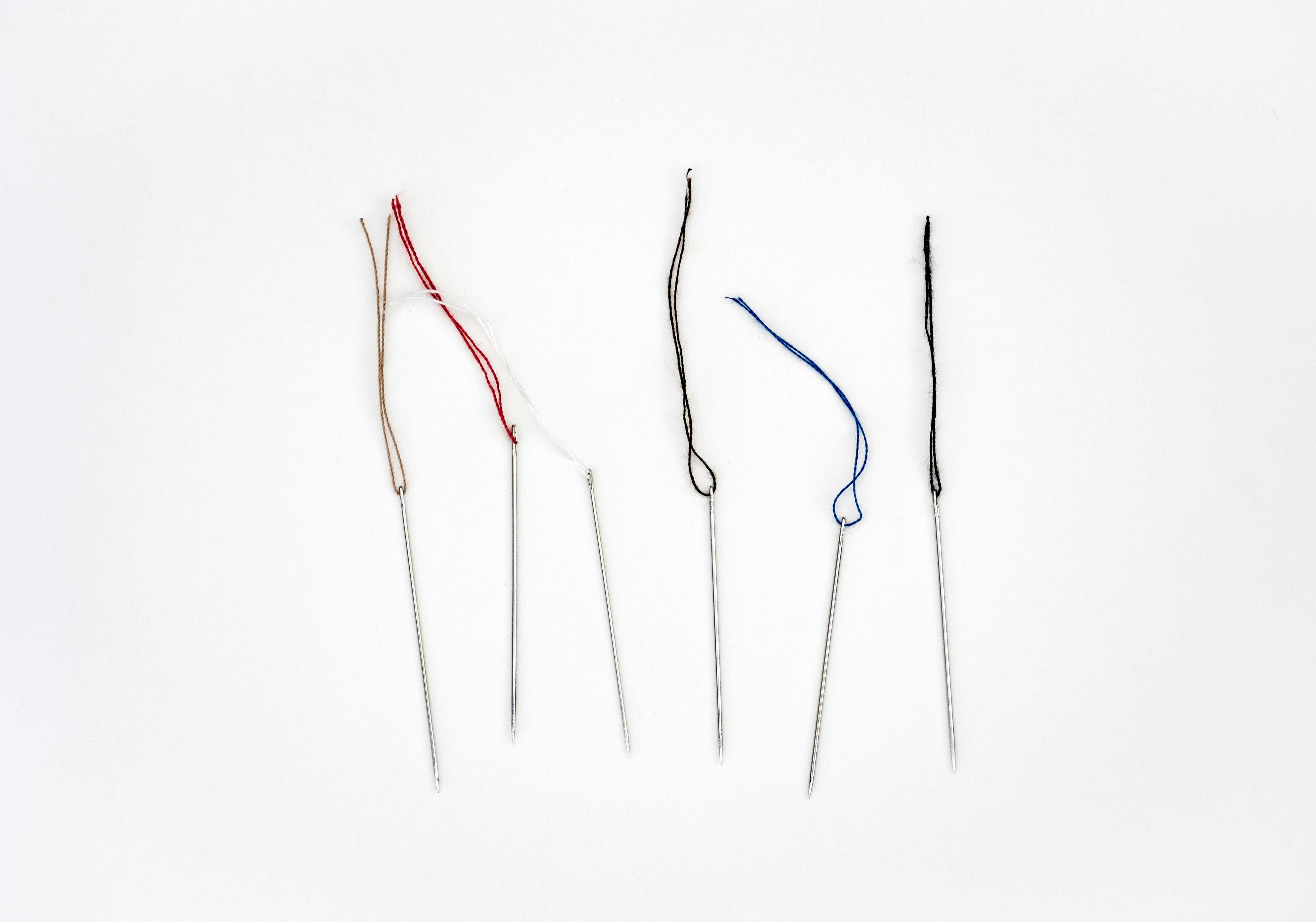 Cross stitch needles with bits of thread