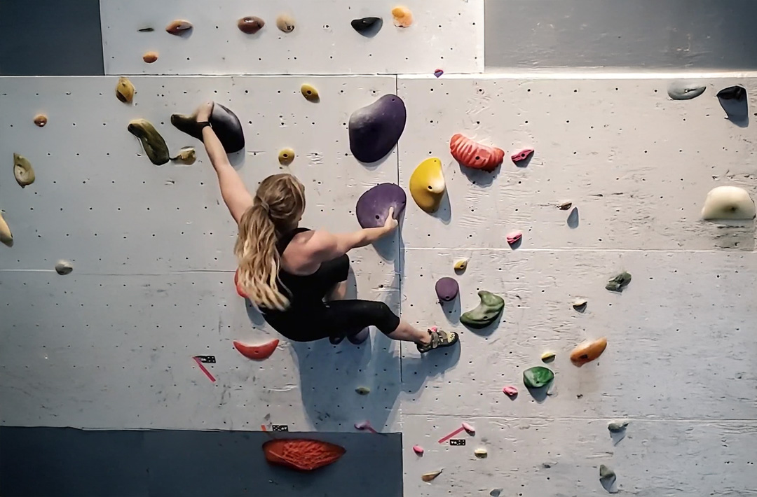 Woman bouldering in a gym