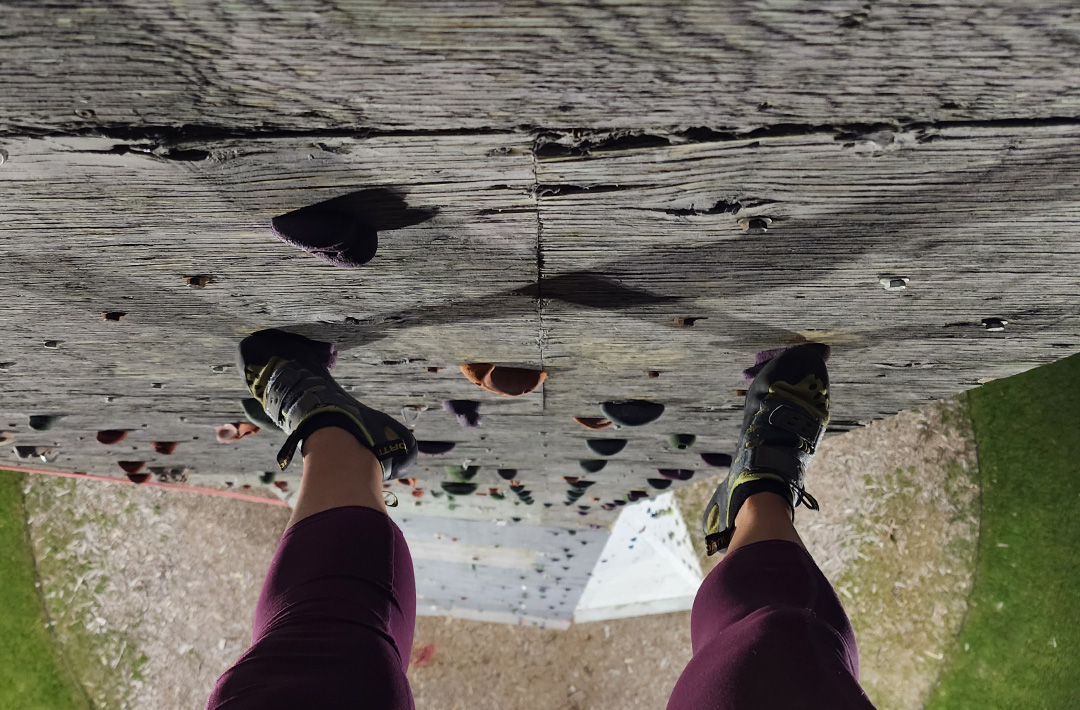View looking down between climber's feet, from 60 feet in the air