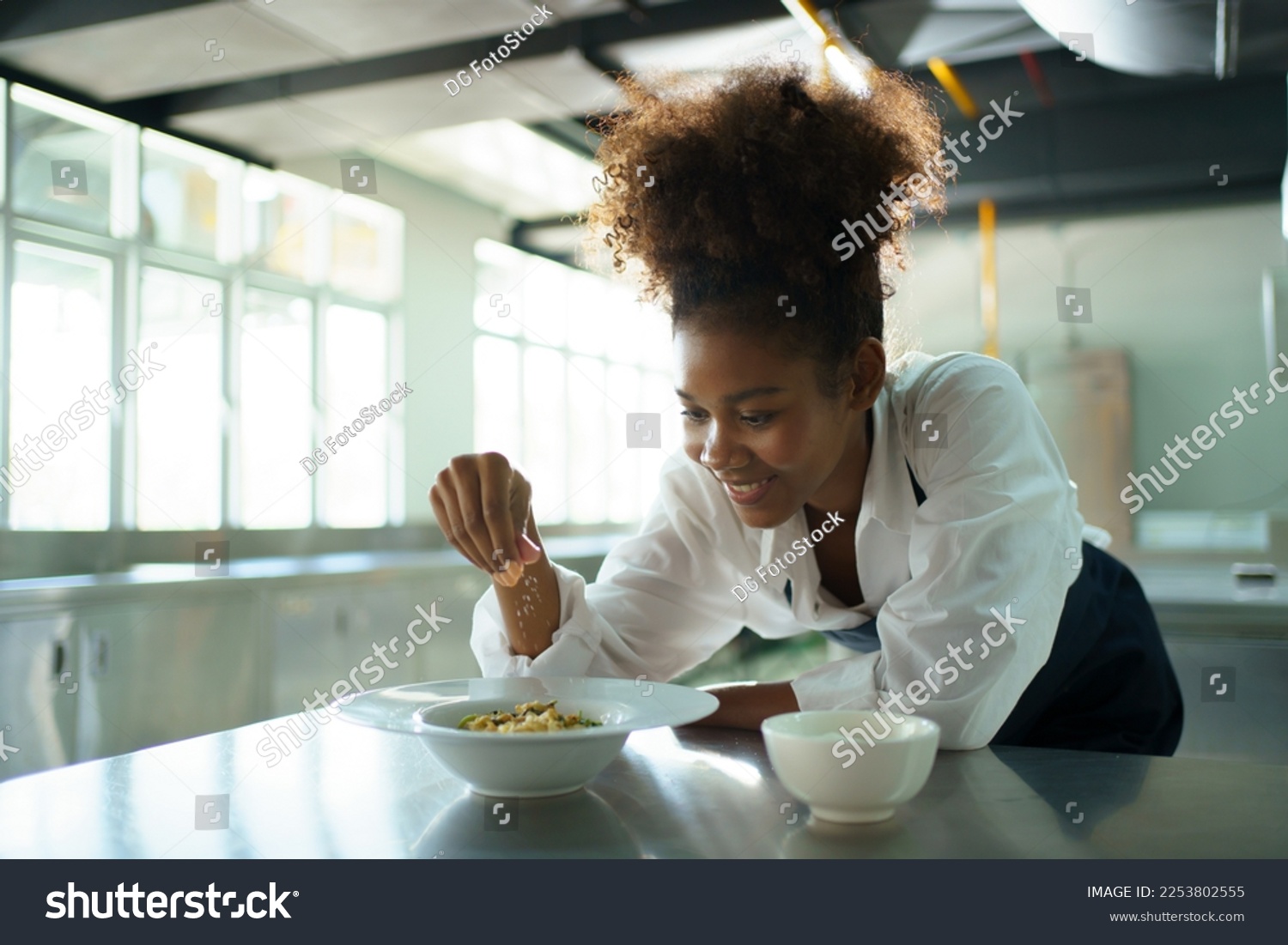 Female chef adding a sprinkle of seasoning