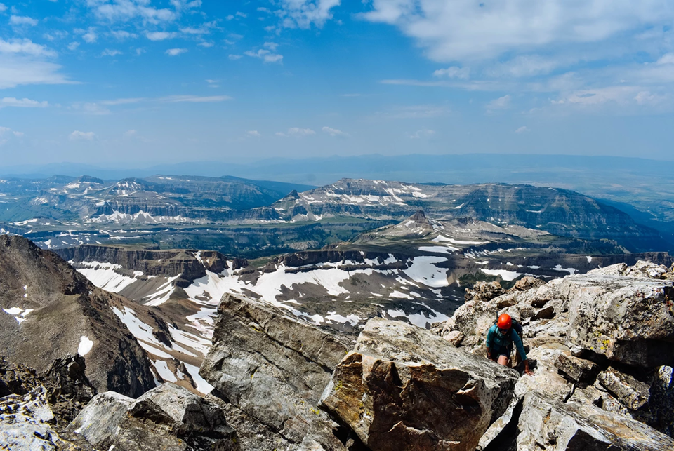woman with helmet on top of mountain