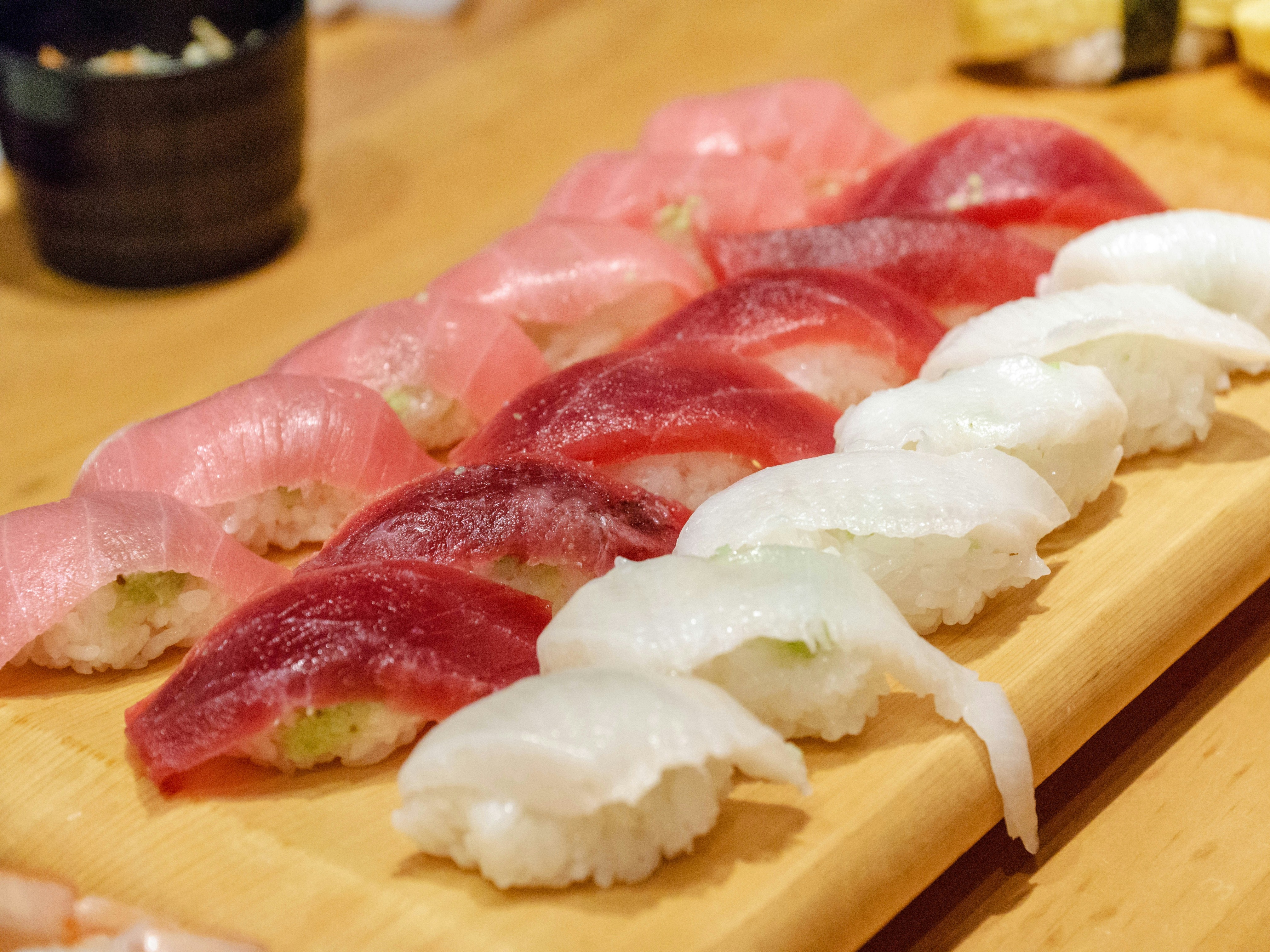 An elegant assortment of sushi on a wooden tray, showcasing fresh ingredients.